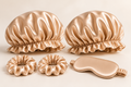 Bonnet Pair Beauty Sleep Set in Champagne: two double-layer ruffled-edge bonnets, one silk sleep mask and two 3 cm silk scrunchies. Product-only image; no gift box included.